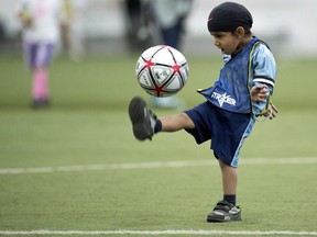 Harshaan Ahluwalis, 2, dribbles a soccer ball during a friendly soccer match in solidarity with young players who wear turbans Saturday, June 15, 2013 in Montreal. If a turban ban stirred such passions, what will an even broader debate over religious accommodation lead to in Quebec this fall? And what about the PQ's attempts to toughen Bill 101? THE CANADIAN PRESS/Paul Chiasson
