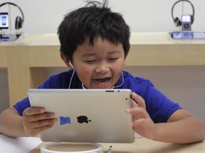 Lucas Bobaco, 8, makes a soundtrack as he sings into an Apple iPad at Camp Apple at an Apple store in Palo Alto, Calif.