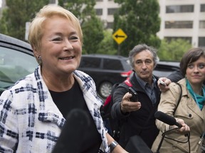 Quebec Premier Pauline Marois smiles as she is questioned over a proposed Charter of Quebec values while walking to her office to attend a cabinet meeting today at the legislature in Quebec City. But is the charter, and it's proposed ban on religious garb in the civil service, about Quebec identity or boosting the PQ's poll numbers? THE CANADIAN PRESS/Jacques Boissinot