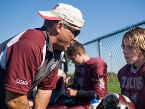 Coach Cliff Wilson talks to player Josh Welburn, age 13, during a game against the Lakeshore Cougars on Sept. 28.