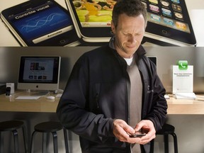 Bruno Verner checks out an iPhone at the Apple in Montreal. The average Canadian cellphone bill jumped 9.8 per cent in 2012.