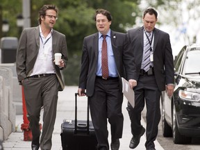 Bernard Drainville, Quenbec minister responsible for Democratic Institutions and Active Citizenship, flanked by press attache Manuel Dionne, left, and a member of his staff walk to a cabinet meeting last week. Drainville is expected to unveil a new Charter of Quebec Values tomorrow. THE CANADIAN PRESS/Jacques Boissinot