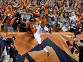 Denver Broncos wide receiver Andre Caldwell (12) is congratulated by fans after his touchdown against the Baltimore Ravens during the second half of an NFL football game, Thursday, Sept. 5, 2013, in Denver. (AP Photo/Jack Dempsey)