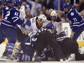Buffalo Sabres and Toronto Maple Leafs pile-up during third period NHL hockey action in Toronto, Sunday Sept. 22, 2013. THE CANADIAN PRESS/Frank Gunn
