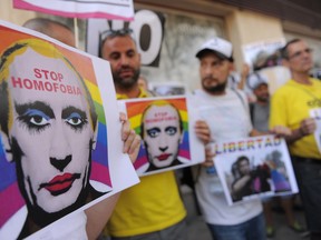 Protestors hold graphic images of Russian President Vladimir Putin wearing lipstick during a protest against Russian anti-gay laws opposite the Russian embassy on August 23, 2013 in Madrid, Spain. Lesbian, gay, bisexual and transgender rights activists in Russia said today they've been invited to meet with U.S. President Barack Obama on the sidelines of this week's G20 summit in Russia. (Photo by Denis Doyle/Getty Images)