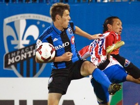 MONTREAL, QUE.: SEPTEMBER 24, 2013 -- Montreal Impact's Maxim Tissot, left and CD Heredia's Osmar Lopez compete for the ball during CONCACAF League of Champions game in Montreal Tuesday September 24, 2013.                 (John Mahoney/THE GAZETTE)