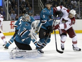 San Jose Sharks goalie Antti Niemi (31) block a goal attempt by Phoenix Coyotes left wing Rob Klinkhammer (36) as San Jose Sharks defenseman Jason Demers (5) defends during the second period an NHL hockey game in San Jose, Calif., Saturday, Oct. 5, 2013. (AP Photo/Tony Avelar)