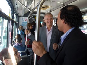 In this file photo from Sept. 5, Marcel Côté, candidate to be mayor of Montreal, speaks to a man on an STM bus on St. Laurent Blvd. Côté announced that he will be boarding a bus weekly to speak to citizens about whatever may be on their minds. Given that a survey conducted the first week of October suggests 51 per cent of respondents don't even know who he is, Côté, may need to ride more frequently on public transit. (John Kenney / THE GAZETTE)