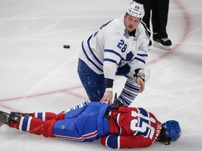 Montreal Canadiens right wing George Parros lays on the ice after falling unconscious after a fight with Toronto Maple Leafs right wing Colton Orr, top, during the third period of the NHL hockey season opening match between the Montreal Canadiens and the Toronto Maple Leafs in Montreal on Tuesday night. Parros was later found to have suffered a concussion. (Dario Ayala / THE GAZETTE)