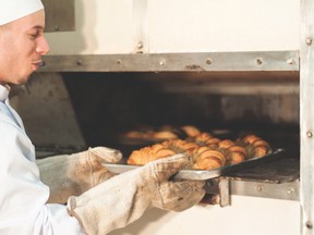 Jakub Szrodt taking out a batch of croissants out of the oven. (photo courtesy of Numéro 9)