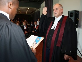 Federal justice department lawyer Claude Bernard swears-in George Springate as Canada's senior Citizenship Judge in October 2008.
