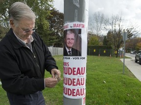 Morris Trudeau puts up posters.