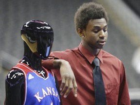 Kansas guard Andrew Wiggins stands next to a mannequin in a KUansas University uniform during Big 12 NCAA college basketball media day in Kansas City, Mo., Tuesday, Oct. 22, 2013. (AP Photo/Orlin Wagner)