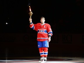 MONTREAL, CANADA - JANUARY 19:  Brian Gionta #21 of the Montreal Canadiens raises a torch during pre-game ceremonies prior to facing the Toronto Maple Leafs in their NHL game at the Bell Centre on January 19, 2013 in Montreal, Quebec, Canada.  The Maple Leafs defeated the Canadiens 2-1.  (Photo by Richard Wolowicz/Getty Images)