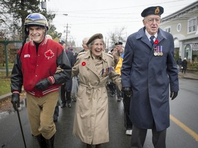 Maxine Bredt, 94, who served in Italy and England during World War II is escorted by Gary MacDonald, left, and Norm St. Aubin, right, at the head of the parade of veterans in the Remembrance Day parade in Hudson.