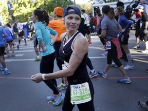 Actress Pamela Anderson smiles after crossing the finish line at the 2013 New York City Marathon in New York, Sunday, Nov. 3, 2013. (AP Photo/Seth Wenig)