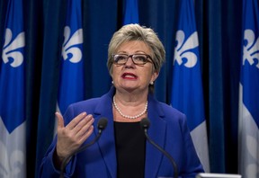 Quebec Minister of Immigration and Cultural Communities Diane De Courcy responds to reporters questions after the government decided to abandon legislation on language, Thursday, November 14, 2013 at the legislature in Quebec City. THE CANADIAN PRESS/Jacques Boissinot