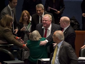 Embattled Toronto Mayor Rob Ford  runs over a fellow councillor while running to his brother, Councillor Doug Ford, after Mayor Ford instigated members of the crowd by having his driver take photographs of the attending public as council strips  the troubled city leader of Mayoral powers at council chambers, on Monday. Ford has vowed a "war" with those who reduced him to a mayor in name only. But with a year before the next election, is a war he could win? [Peter J. Thompson/National Post]