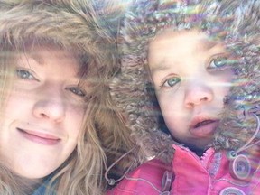 Megan Lovelace and Rachel Lajeunesse watch their Uncle Nick cut down a Christmas tree at Hadley's in Lachute.