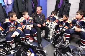 Assistant coach Cliff Albert talks to his team in the locker room before a game.