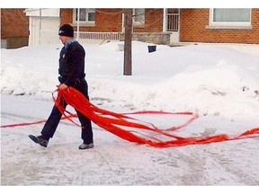A police officer takes down police tape after a shooting incident in Dorval Jan.22, 2013.