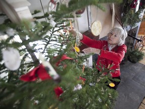 Audrey Wall, executive director of the Greenwood Centre For Living History, fixes ornaments on the centre's Christmas tree in Hudson on Sunday, Dec. 1, 2013.