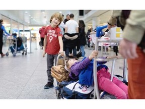 Maël Goyette plays with his sister Margot Goyette at Trudeau airport, as their mother Catherine Goyette tried to sort out a booking error that delayed their flight to Punta Cana, Dominican Republic.