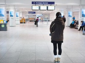 A young woman monitors the arrivals board at Trudeau airport on Tuesday.