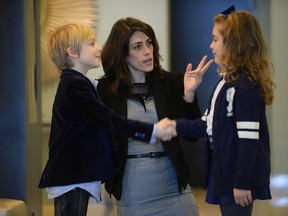 Ana Tajuelo teaches 7-year-old Audra and 6-year-old Johnathan Xinos how to properly shake hands. (Graham Hughes/THE GAZETTE)