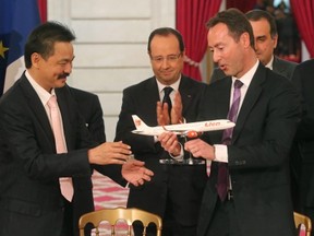 Airbus CEO Fabrice Bregier, right, hands over an Airbus 320 model to CEO of Lion Air, Indonesian Rusdi Kirana, left, last March at a ceremony at the Elysee palace while France's President Francois Hollande looks on.
Lion Air is to buy 234 short to medium range aircraft from Airbus for 18.4 billion Euro ($24 billion), in what is being billed as the biggest civilian deal in the history of the aircraft manufacturer.