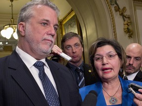 Quebec Opposition member Fatima Houda-Pepin responds to reporters questions as Quebec Libral Party Leader Philippe Couillard, left, looks on following a party caucus meeting, Tuesday, November 19, 2013 at the legislature in Quebec City. A letter sent by Houda-Pepin had created discomfort with the Liberal caucus and caused the party to soften its stand on a ban on religious symbols in the public service. But will the latest reversal by the Liberals on the ban - now opposing it completely, cause a rift within party ranks? THE CANADIAN PRESS/Jacques Boissinot