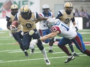 Montreal's Marc-Olivier Brouillette, tackling Winnipeg's Johnny Sears, has re-signed with the Als.
Graham Hughes/Canadian Press