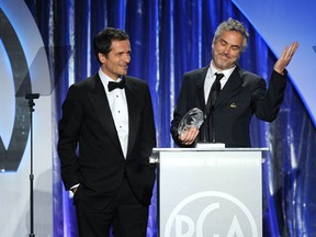 Producer David Heyman (L) and director-producer Alfonso Cuaron accept the Darryl F. Zanuck Award for Outstanding Producer of Theatrical Motion Pictures for 'Gravity' during the 25th annual Producers Guild of America Awards at The Beverly Hilton Hotel on January 19, 2014 in Beverly Hills, California.  (Kevin Winter/Getty Images)