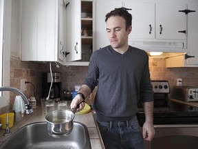 Jarrod White holds up a pot of water he boiled his home in Vaudreuil-Dorion on January 25, 2014.