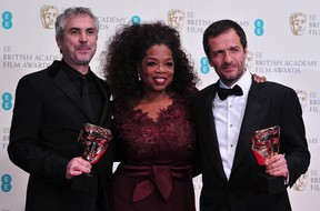 Mexican filmmaker Alfonso Cuaron (L) and British producer David Heyman (R)  flank presenter Oprah Winfrey (C) with their awards for an Outstanding British Film for Gravity at the BAFTA British Academy Film Awards at the Royal Opera House in London on February 16, 2014. (CARL COURT/AFP/Getty Images)