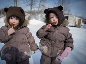 3 year old twins , Charlotte (left) and Reilly Gunning (right) enjoy maple taffy at the annual winter festival in Dollard des Ormeaux's William Cosgrove Centennial Park  Sunday, February 9, 2014. (Peter McCabe / THE GAZETTE)