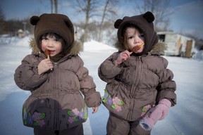 3 year old twins , Charlotte (left) and Reilly Gunning (right) enjoy maple taffy at the annual winter festival in Dollard des Ormeaux's William Cosgrove Centennial Park  Sunday, February 9, 2014. (Peter McCabe / THE GAZETTE)