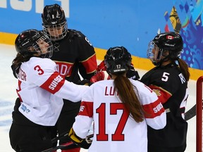 Sarah Forster #3 of Switzerland fights with Lauriane Rougeau #5 of Canada during the Women's Ice Hockey Preliminary Round Group A Game Feb. 8 in Sochi, Russia.