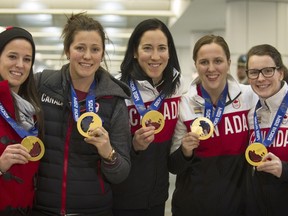 Melodie Daoust, Charline Labonte, Caroline Ouellette, Lauriane Rougeau and Catherine Ward hold up their medals on their arrival at Trudeau Airport on Tuesday, Feb. 25.