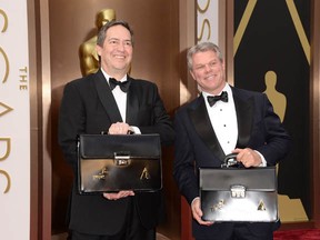 These guys have the answers! PricewaterhouseCoopers representatives have the Oscar envelopes in their briefcases, on March 2, 2014 in Hollywood, California.  (Jason Merritt/Getty Images)