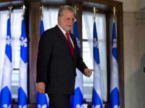 Quebec Premier Philippe Couillard walks to a news conference following his first cabinet meeting, Thursday, April 24, 2014 at his office in Quebec City. The newly elected premier has publicly stated Quebec's finances need to be cleaned up, but experts warned today that without popular support for proposed budget cuts, there could be marching in the streets. THE CANADIAN PRESS/Jacques Boissinot ORG XMIT: jqb101