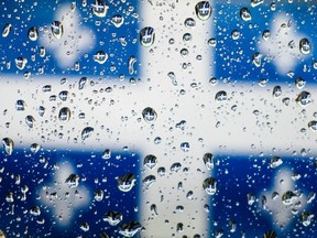The Quebec flag seen through water drops on a window in Montreal on Tuesday, April 8, 2014 . (Dario Ayala / THE GAZETTE)