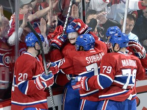 Montreal Canadiens left wing Max Pacioretty (67) is mobbed by teammates after scoring the winning goal against the Tampa Bay Lightning during third period National Hockey League Stanley Cup playoff action on Tuesday, April 22, 2014 in Montreal. THE CANADIAN PRESS/Ryan Remiorz