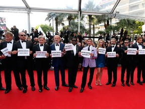 The cast of The Expendables 3, from left, actors Glen Powell and Dolph Lundgren, director Patrick Hughes, actors Harrison Ford,  Kelsey Grammer, Wesley Snipes, Sylvester Stallone, Ronda Rousey, Mel Gibson, Antonio Banderas, Kellan Lutz, Randy Couture,  Jason Statham and boxer and actor Victor Ortiz hold signs reading Bring Back Our Girls, in support of kidnapped Nigerian schoolgirls, at the Cannes Film Festival on May 18, 2014.     (VALERY HACHE/AFP/Getty Images)