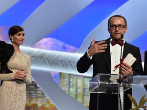 Director and screenwriter Andrei Zvyagintsev makes his thank-you speech after receiving the Best Screenplay Prize for his film Leviathan from actress Paz Vega at the Cannes Film Festival on May 24, 2014 in Cannes, France.  (Photo by Pascal Le Segretain/Getty Images)