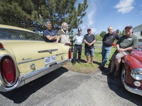Members of the Hudson Antique Car Club with a couple of the cars that will be on display at the British Car Show at St. Thomas Park in Hudson on May 24.