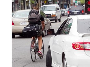 A cyclist makes his way north on St-Denis St. near Rachel St. in the Plateau on Thursday. The Plateau-Mont-Royal borough announced road-safety measures., which will include the widening of parking lanes on St-Denis to reduce the “dooring” of cyclists.