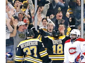 Fans celebrate with Boston Bruins right wing Reilly Smith (18) and centre Patrice Bergeron (37) after Smith’s goal during the third period in Game 2 of an NHL hockey second-round playoff series against the Montreal Canadiens in Boston, Saturday, May 3, 2014. Canadiens defenceman P.K. Subban (76) skates near at right. The Bruins won 5-3.