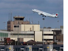 An Air Canada passenger jet takes off over the terminal at Halifax Stanfield International Airport in Halifax on Jan. 21, 2013. Air Canada is reporting a first-quarter net loss of $341 million, or $1.20 per diluted share, as it was impacted by a lower Canadian dollar.