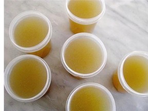 Homemade chicken stock sits on the counter to cool before freezing.